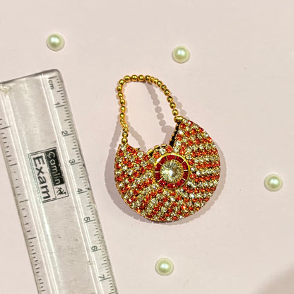 AD Moon Shaped Purse for deity shringar, a small crescent stone-studded purse available in red, dark blue, pink, sky blue, green and orange