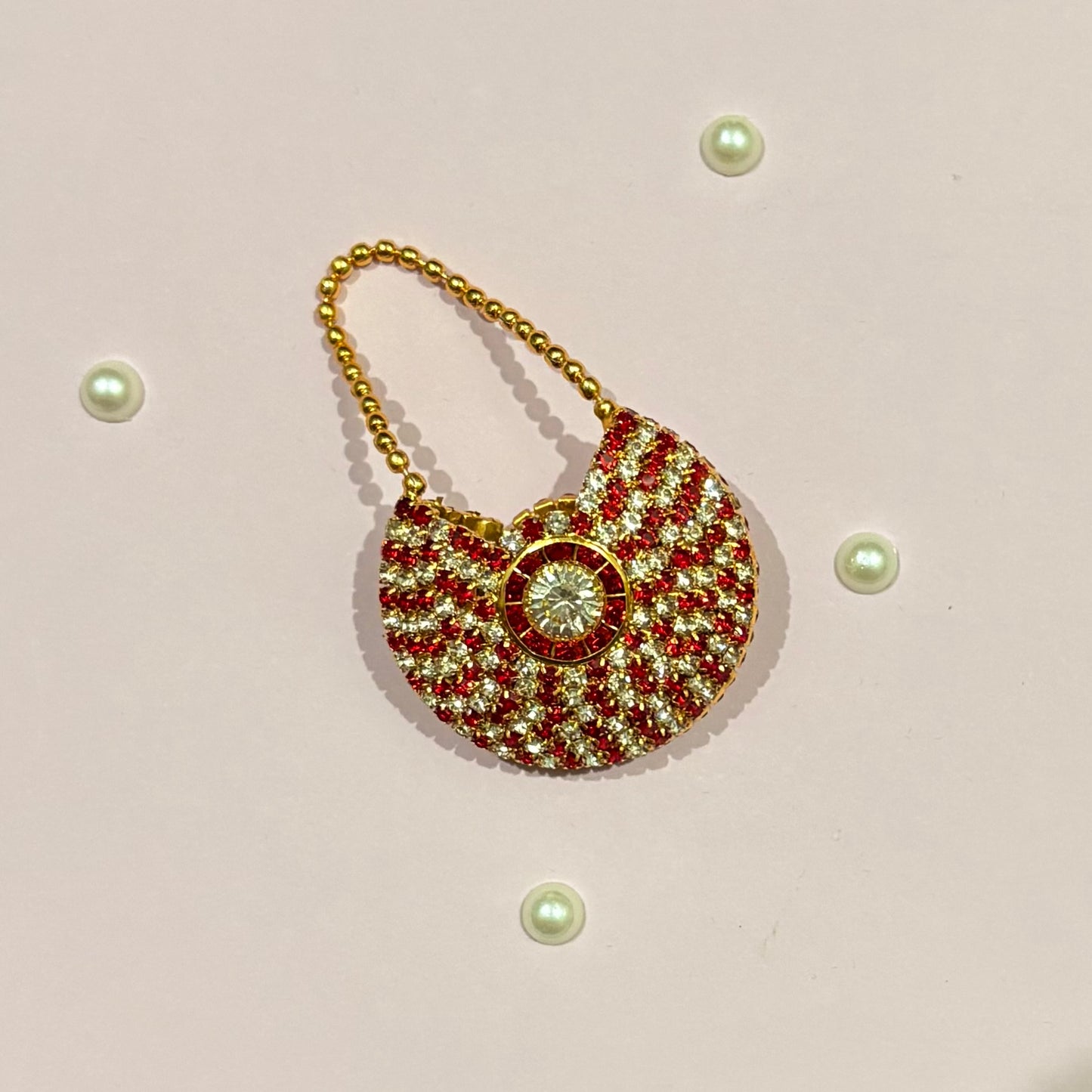 Red AD Moon Shaped Purse, a small gold-tone stone-studded crescent purse to adorn deity idols like Radha Rani and Laddu Gopal
