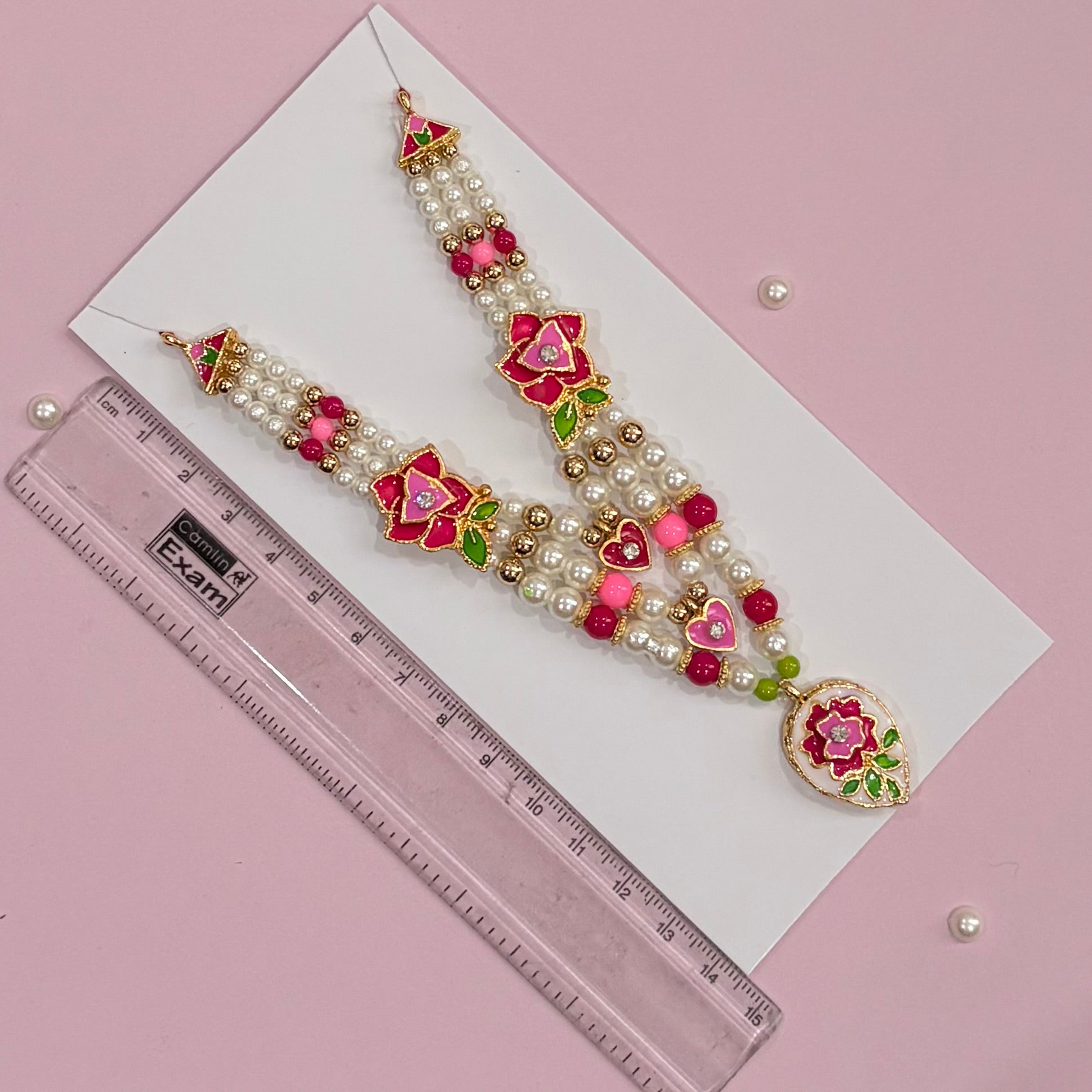 Close-up of the pink Mala deity necklace with intricate gold-tone stonework for Radha Rani and Laddu Gopal shringar