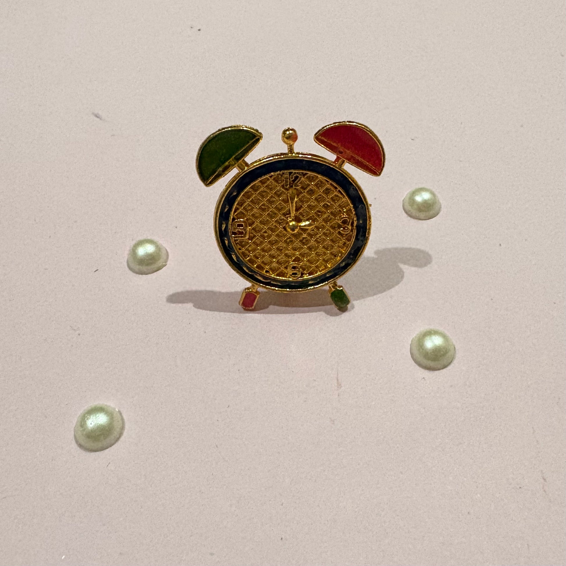 Close-up of the miniature Metal Clock with intricate gold-tone detailing, a decorative accessory for deity shringar and miniature settings