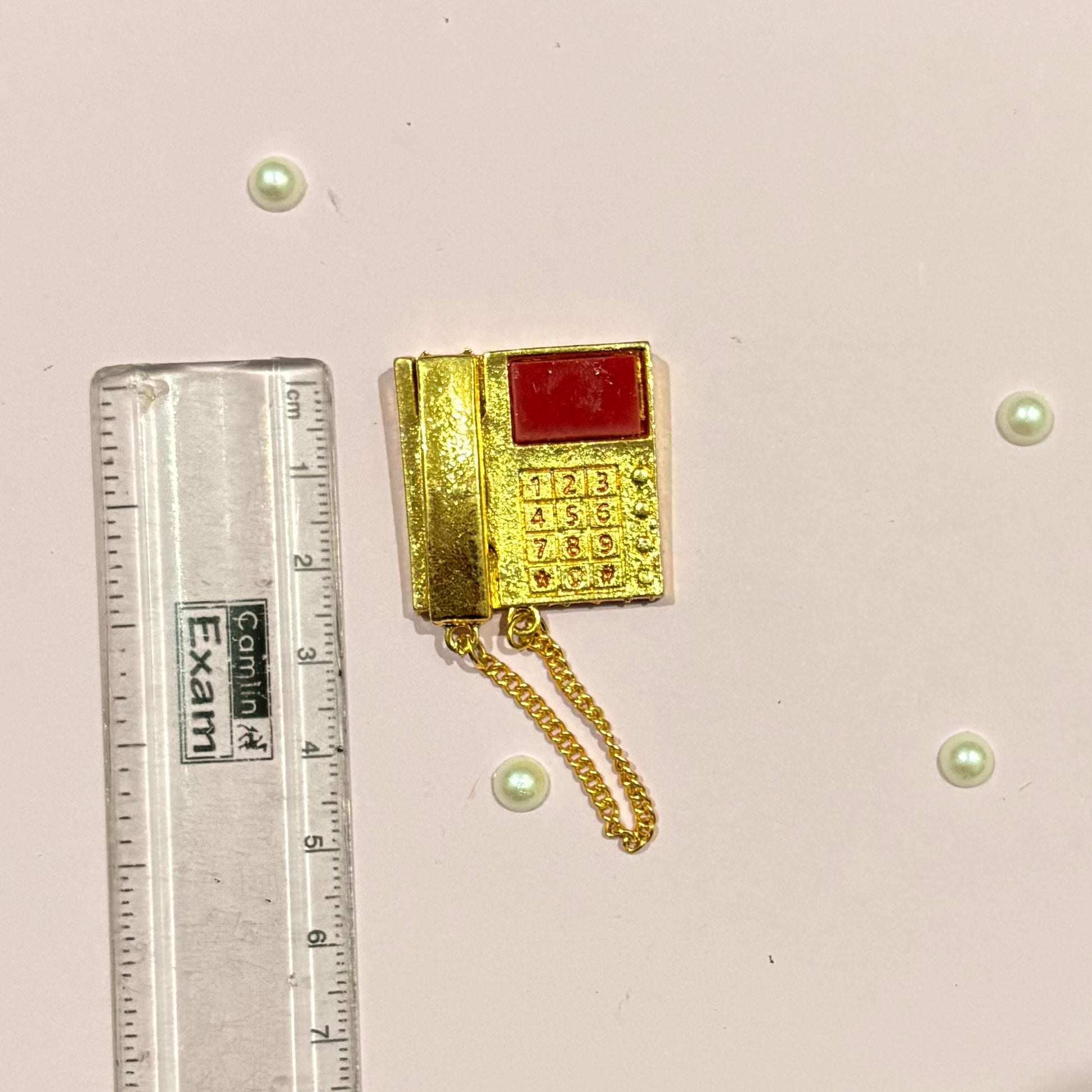 Close-up of the miniature metal Telephone with intricate gold-tone detailing, a decorative toy accessory for deity and miniature settings