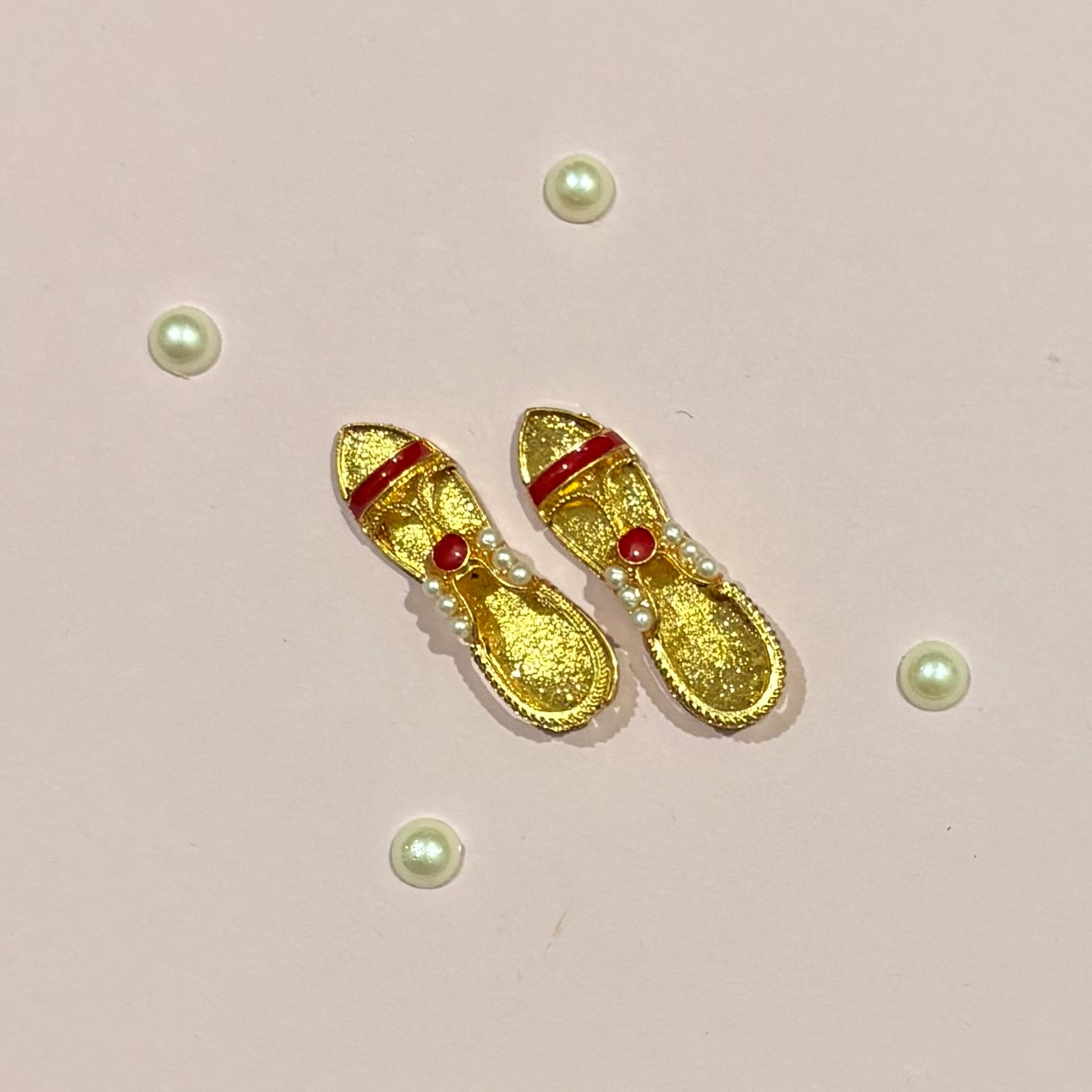 Miniature gold-tone Sandal (charan paduka) for deity seva, a handcrafted pair representing the holy feet of idols like Radha Rani and Laddu Gopal
